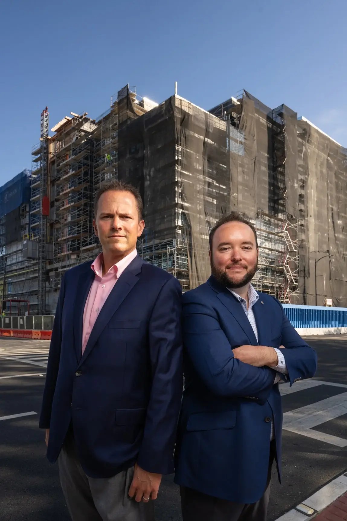 Two Urban Catalyst team members in front of a building under construction